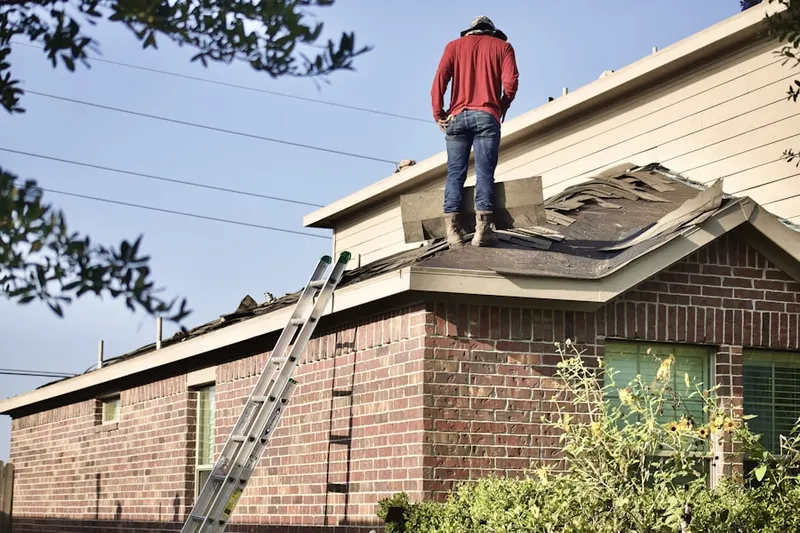 Professional roofer working on a residential roof in Laura